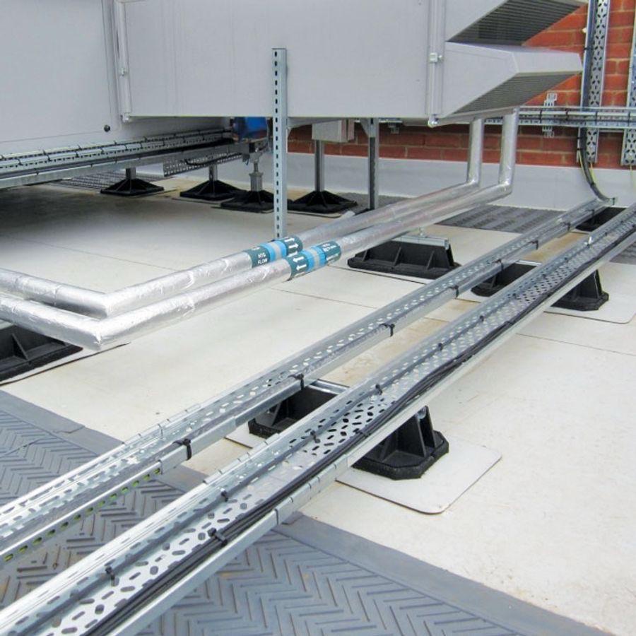 Cable trays and insulated pipework on low-level rooftop supports